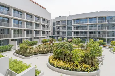 an exterior view of an apartment building with plants at Very Cozy & Relaxing Studio in JVC in Dubai