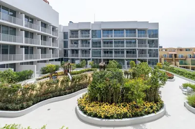 an apartment building with a garden in front of it at Very Cozy & Relaxing Studio in JVC in Dubai