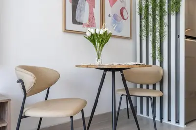 a table with two chairs and a vase with flowers at Work & Relax & Chill in JVC in Dubai