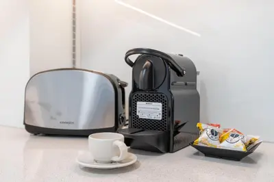 a toaster and a cup of coffee on a counter at Work & Relax & Chill in JVC in Dubai