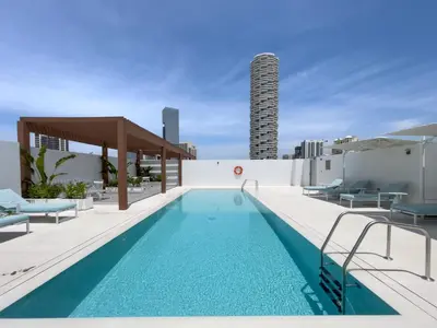 a swimming pool on the roof of a building at Brand New & Modern Studio in JVC in Dubai
