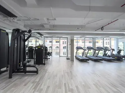 a gym with rows of treadmills and ellipticals at Brand New Vibrant Studio in JVC in Dubai