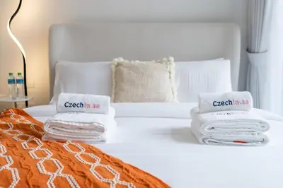 a hotel room with a bed with towels on it at Bright & Modern Studio in JVC in Dubai