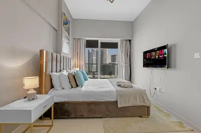 a bedroom with a large bed with a window at Reva Hotel Apartment Downtown in Dubai