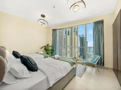 a bedroom with a large bed and a large window at Relax & Unwind in This Cozy 2BR Apartment in Dubai