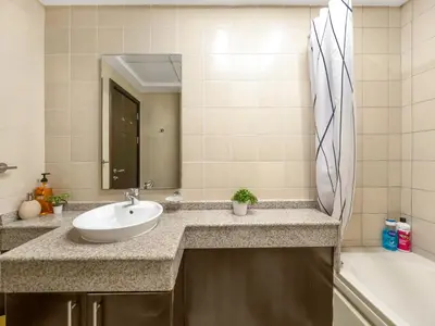 a bathroom with a sink and a mirror and a tub at Relax & Unwind in This Cozy 2BR Apartment in Dubai