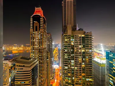a group of tall buildings in a city at night at Relax & Unwind in This Cozy 2BR Apartment in Dubai