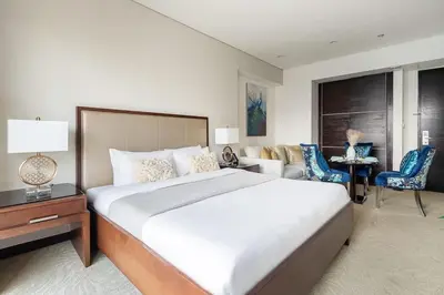 a bedroom with a large bed and a living room at Frank Porter - Emaar Residences Dubai Marina in Dubai