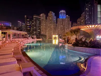 a large swimming pool with a city skyline at night at Frank Porter - Emaar Residences Dubai Marina in Dubai