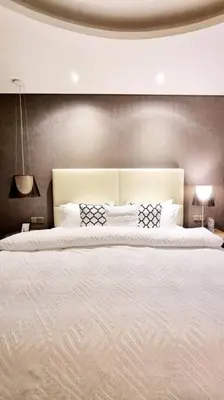 a large white bed in a bedroom with two lamps at Amazing Paramount Hotel apartment D48 in Dubai