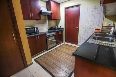 a kitchen with wooden cabinets and a counter top at 2BR Jumeirah Beach front Residence in Dubai