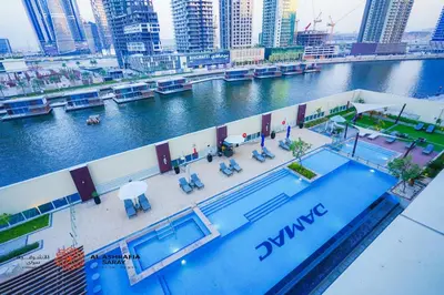 a large swimming pool on the side of a river at Alashrafia Saray - Superb 1 BR in Canal Views in Dubai
