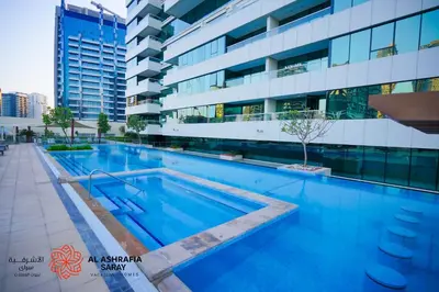 a swimming pool in front of a building at Alashrafia Saray - Superb 1 BR in Canal Views in Dubai