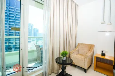 a living room with a chair and a large window at Alashrafia Saray - Fabulous 1BR in Canal Views in Dubai