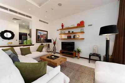 a living room with white furniture and a fireplace at Maison Privee - Splendid Apt on The Palm with Stunning Sea Views in Dubai