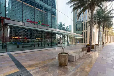 a street in a city with palm trees and a building at Prestige Living 1BR with Full Burj Khalifa View by Auberge in Dubai