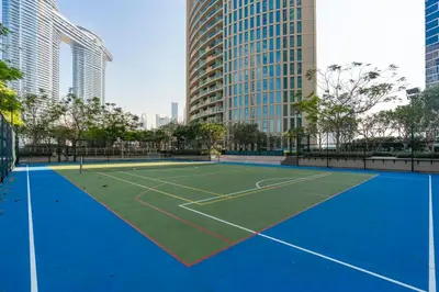a tennis court in a city with tall buildings at Prestige Living 1BR with Full Burj Khalifa View by Auberge in Dubai