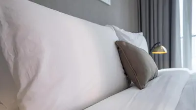 a white bed with a pillow and a lamp at Bright Deluxe Studio canal view - Special offer in Dubai