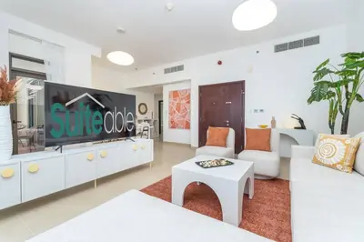 a living room with white furniture and a flat screen tv at Dominant View of Dubai Marina in Dubai