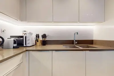 a kitchen with white cabinets and a sink at Marina Gate 1, Dubai Marina - Chic One Bedroom in Dubai