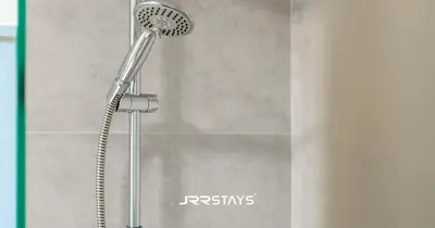 a shower with a shower head in a bathroom at Stylish Studio - Panoramic Pool View - JVC in Dubai
