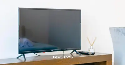 a flat screen tv sitting on top of a table at Stylish Studio - Panoramic Pool View - JVC in Dubai