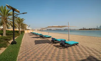 a row of blue benches on the beach at Amazing BeachFront Apartments near Atlantis Waterpark by Simply Comfort Sarai Palm Jumeirah in Dubai