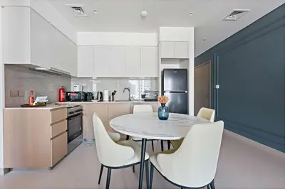 a kitchen with a white table and chairs at Silkhaus Burj Royale 1BDR with balcony in Downtown in Dubai