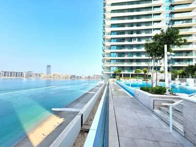 a swimming pool next to a large building at Seaside Serenity: 1-BR Apartment with Beach Access in Dubai