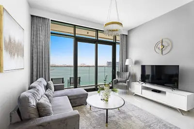 a living room with a couch and a tv at Seaside Serenity: 1-BR Apartment with Beach Access in Dubai