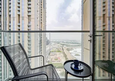a chair and a table in front of a window at The stylish Meera tower 3606 apartment in Al Habtoor city in Dubai