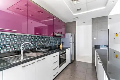 a kitchen with purple cabinets and a sink at StoneTree - Cayan Tower 2 BR - Best Location in Dubai
