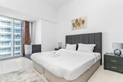 a bedroom with a large bed and a large window at StoneTree - Cayan Tower 2 BR - Best Location in Dubai