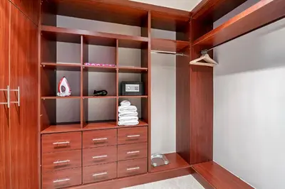 a closet with a wooden cabinet and a dresser at StoneTree - Fairmont North 2 BR - Beach Access in Dubai