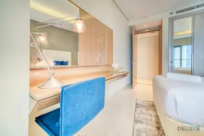 a bedroom with a blue chair and a mirror at Sophisticated 2BR at DAMAC Towers by Paramount A Business Bay by Deluxe Holiday Homes in Dubai