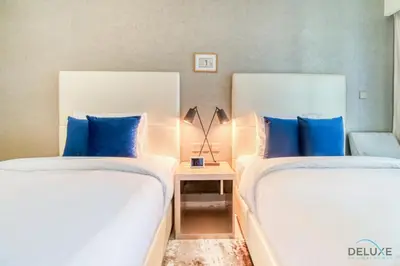 two beds with blue pillows in a bedroom at Sophisticated 2BR at DAMAC Towers by Paramount A Business Bay by Deluxe Holiday Homes in Dubai