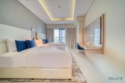 a bedroom with a large white bed and a mirror at Sophisticated 2BR at DAMAC Towers by Paramount A Business Bay by Deluxe Holiday Homes in Dubai