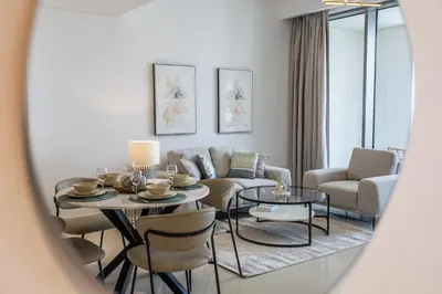 a living room with a table and chairs and a couch at Creek View Apartment in Creek Harbour in Dubai