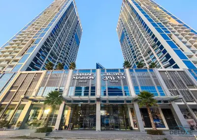 two tall buildings with palm trees in front of a building at Special Offer Elegant Studio with Iconic Canal Views by Deluxe Holiday Homes in Dubai