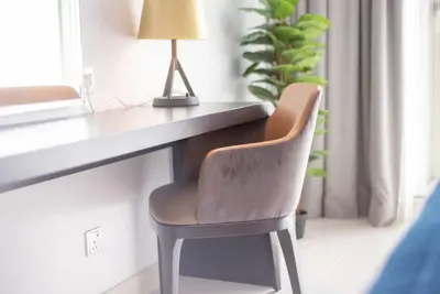 a chair sitting next to a desk with a lamp at Upscale 1 bed apartment in Business Bay-Suiteable in Dubai