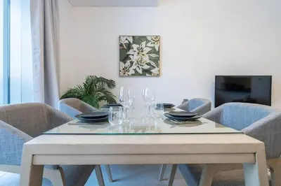 a dining room table with glasses and plates on it at Lush Tropical Getaway in Dubai Marina in Dubai