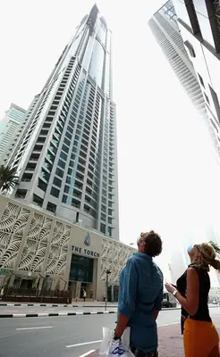 two people standing in front of a large building at Birds Eye 2BR - Torch Tower-L51 - Near Marina Walk in Dubai