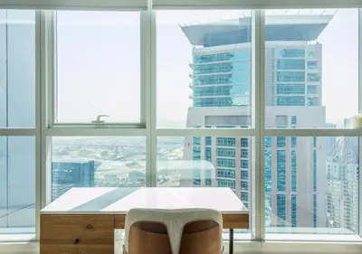 a table and two chairs in a room with windows at Birds Eye 2BR - Torch Tower-L51 - Near Marina Walk in Dubai