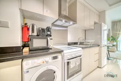 a kitchen with a washer and dryer at Picturesque Studio at Carson A DAMAC Hills Dubailand by Deluxe Holiday Homes in Dubai