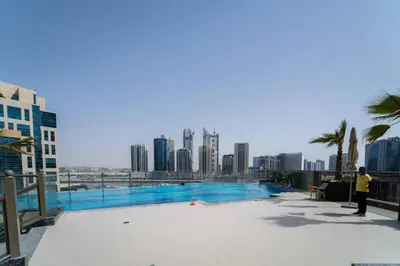 a man standing next to a swimming pool with a city skyline at Romantic hideaway w breathtaking Burj Khalifa view in Dubai