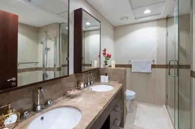 a bathroom with two sinks and a glass shower at Downtown Dubai, Luxury 2 Bed 2 Bath Apartment - Pool, Gym, AirCon, Parking - Views of The Dubai Fountain & Burj Khalifa in Dubai