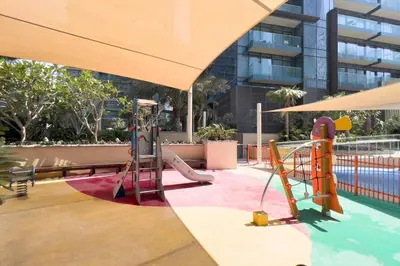 a pool with a slide and a playground at GuestReady - Luxury 1BR | Skyline & Canal View in Dubai