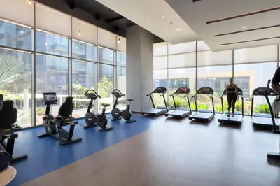 a gym with treadmills and ellipticals in a building at GuestReady - Luxury 1BR | Skyline & Canal View in Dubai