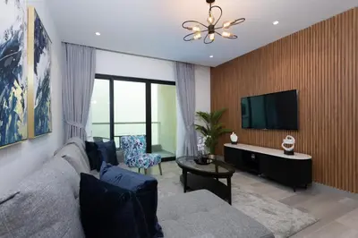 a living room with a couch and a flat screen tv at Modern Brand New 1BR Holiday Homes at Greens in Dubai
