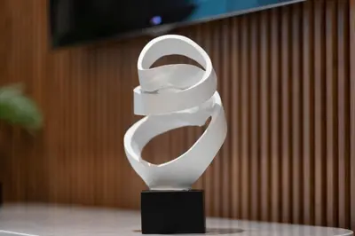 a white sculpture on a black stand on a table at Modern Brand New 1BR Holiday Homes at Greens in Dubai